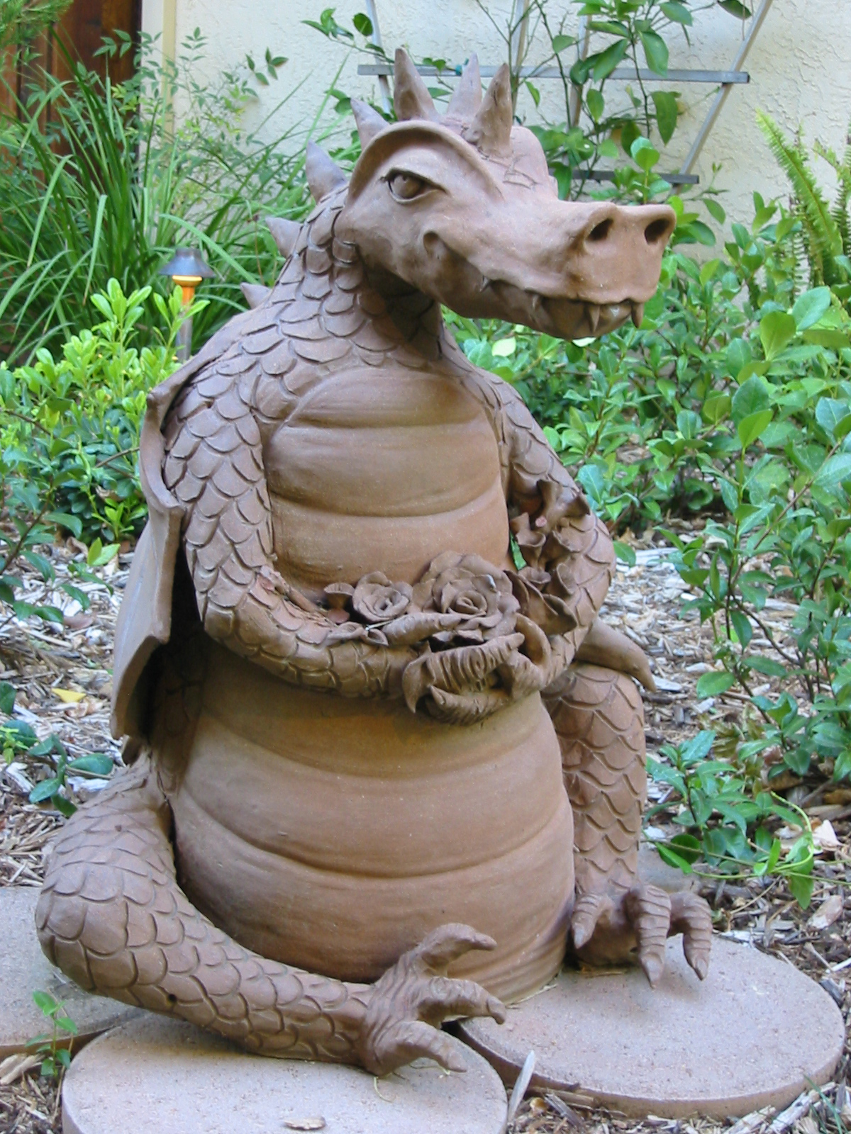 Garden Sculpture of Friendly Dragon Holding Flowers